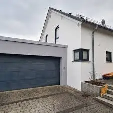 Modernes Haus mit sanierter Fassade und Garage